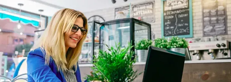 Przedsiębiorczyni pracująca przy laptopie w kawiarni